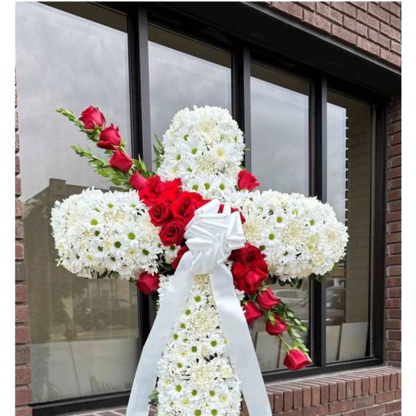 White floral cross with red roses and a white ribbon