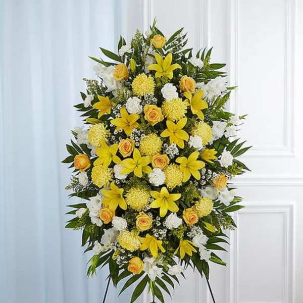 Standing floral spray with yellow and white flowers on an easel