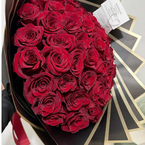 Bouquet of red roses wrapped in black and gold paper