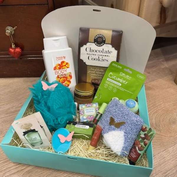 Gift basket with body wash, cookies, face mask, and small accessories
