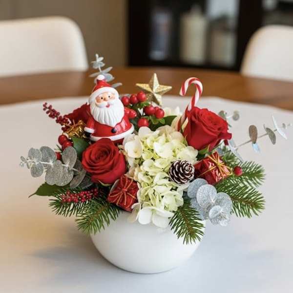 Christmas arrangement with red roses in a white bowl vase