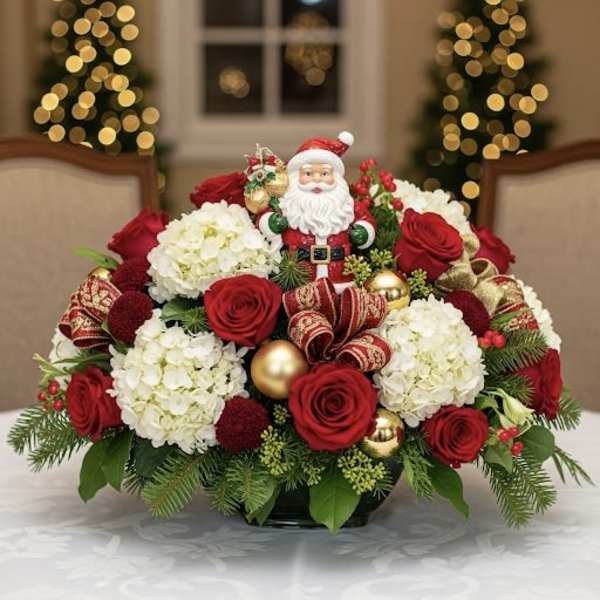 Christmas arrangement with red roses, white hydrangeas, and a Santa figurine