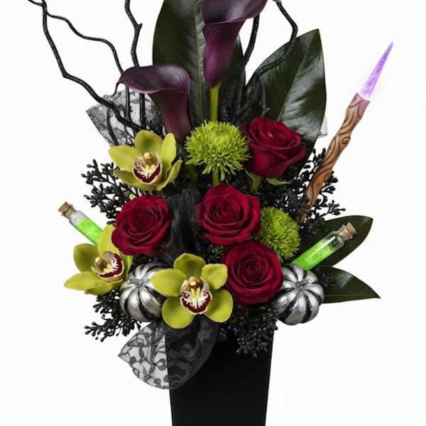 Tall arrangement of red roses and purple calla lilies in a black vase
