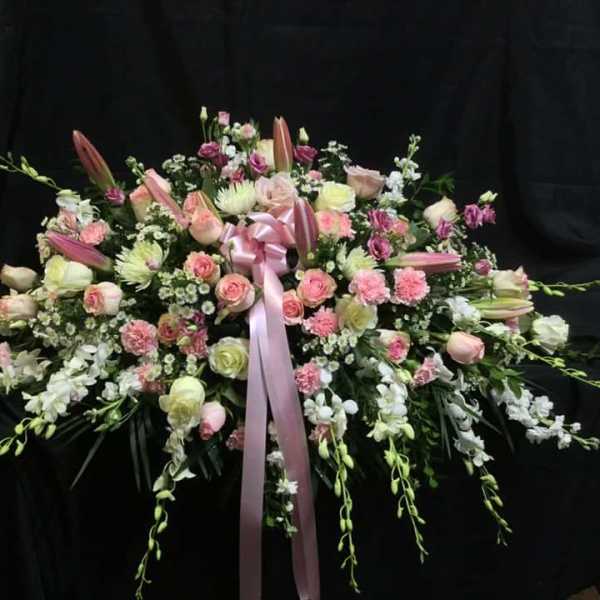 Large pink and white floral spray with a ribbon bow