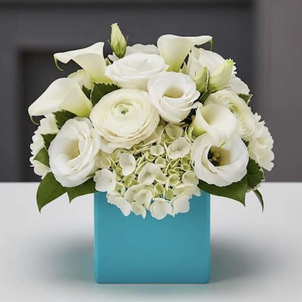 White floral arrangement in a blue square vase