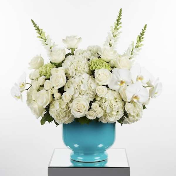 White floral arrangement in a turquoise vase