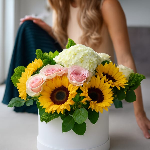 Bouquet of sunflowers, pink roses, and white hydrangea in a white hat box