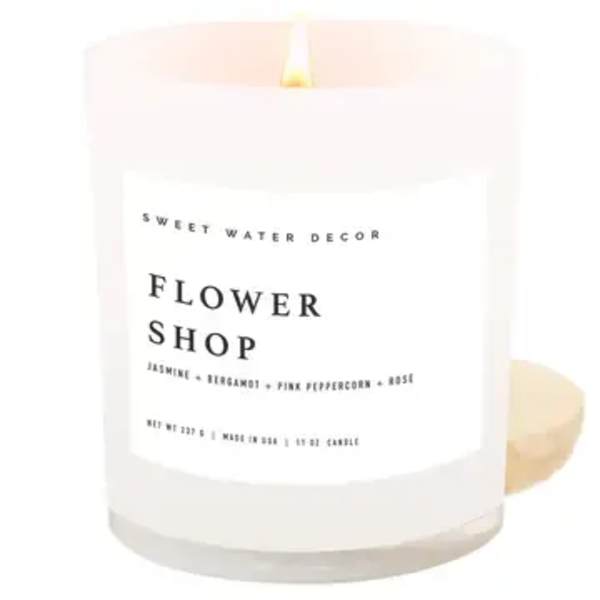White candle in a glass jar labeled Flower Shop