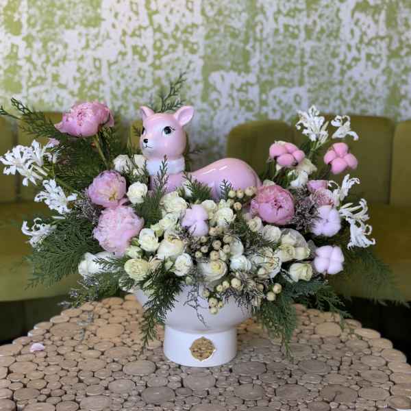 Pink deer figurine surrounded by pink and white flowers in a white vase