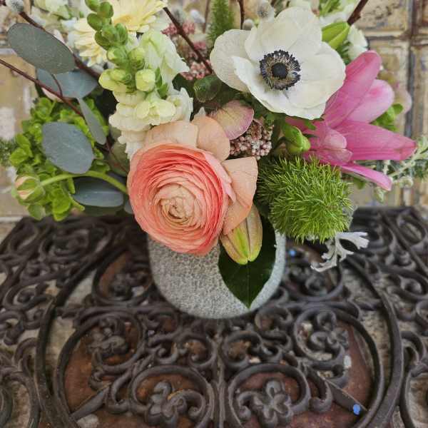 Mixed bouquet in a gray vase with pink, white, and yellow blooms
