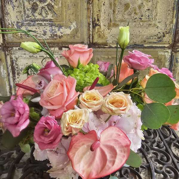 Mixed bouquet of pink and peach roses with an anthurium bloom