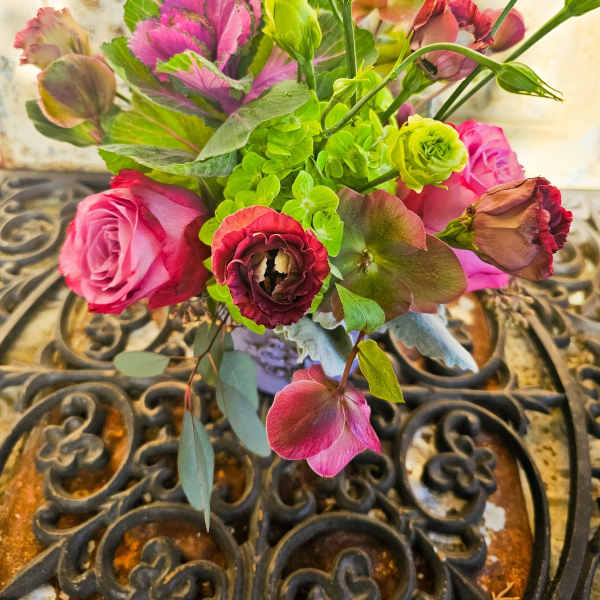 Bouquet of pink roses and green blooms in a vase