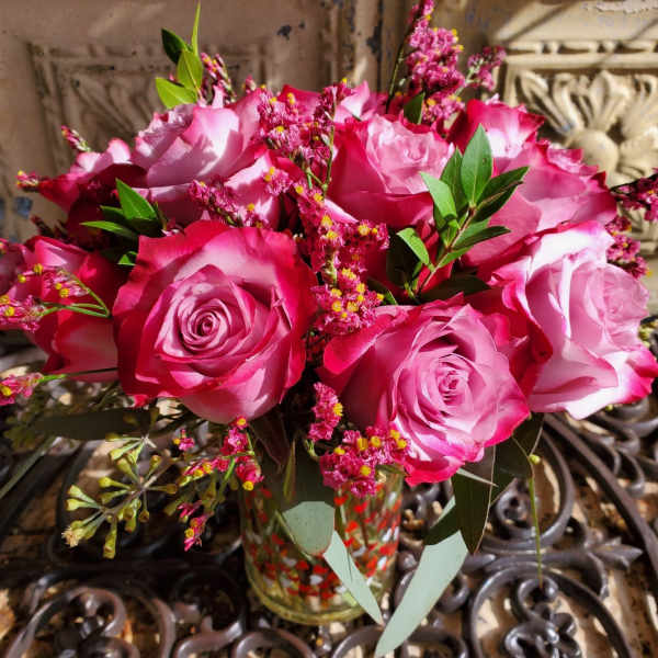 Pink and white roses arranged in a glass vase