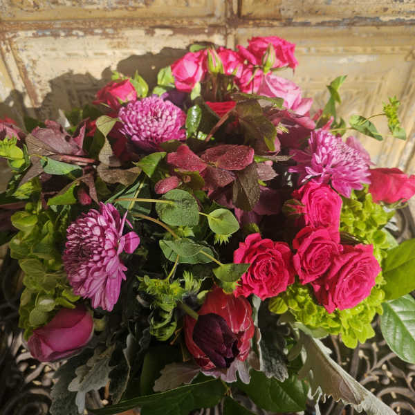 Bouquet of pink roses and purple chrysanthemums with mixed greenery