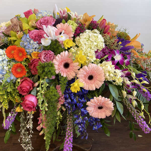 Large colorful floral arrangement with roses, gerbera daisies, and orchids