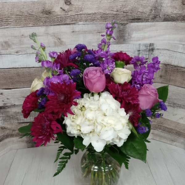 Bouquet of pink, white, and purple flowers in a glass vase