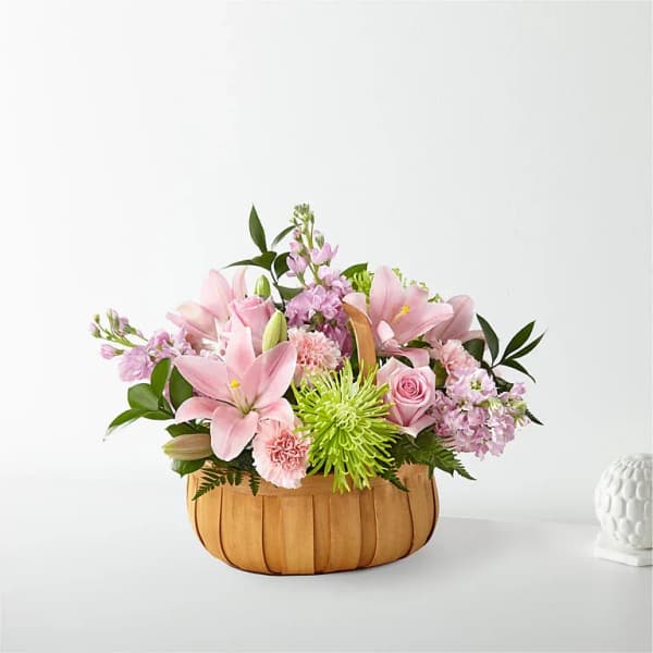 Pink lilies and roses in a woven basket