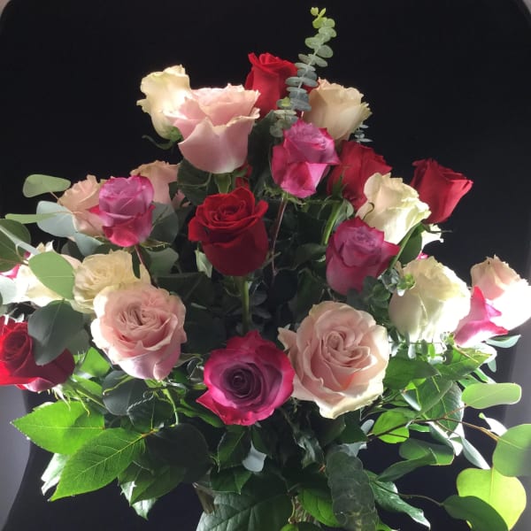 Bouquet of red, pink, and white roses in a glass vase