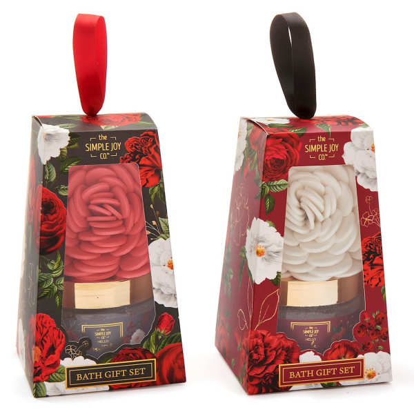 Two floral-patterned bath gift sets with rose-shaped candles in red and white boxes