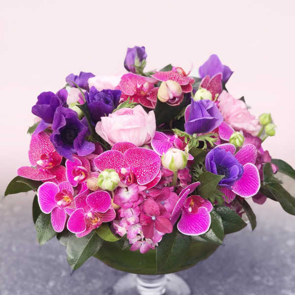 Pink and purple floral arrangement in a glass vase