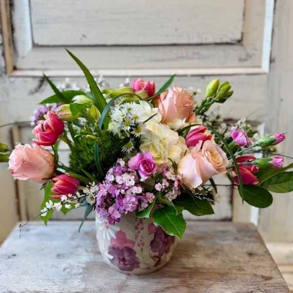 Mixed pink and white flower arrangement in a ceramic vase