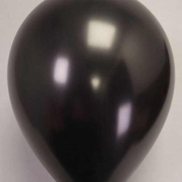 Single black balloon on a plain background