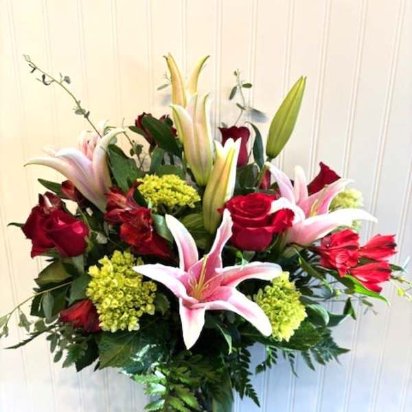 Bouquet of red roses and pink lilies in a gold vase