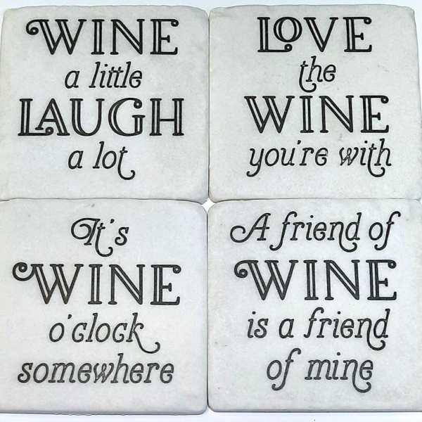Four white coasters with black wine-themed sayings