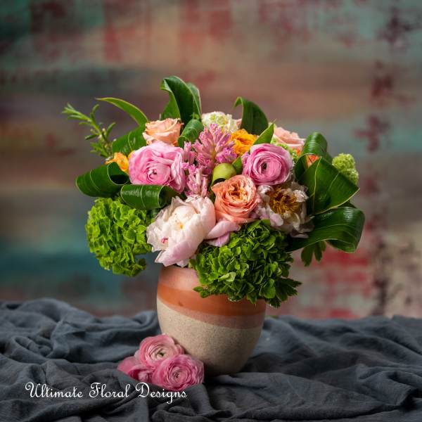 Pink and peach flowers arranged in a ceramic vase