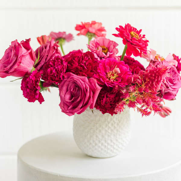 Pink and magenta mixed bouquet in a white textured vase