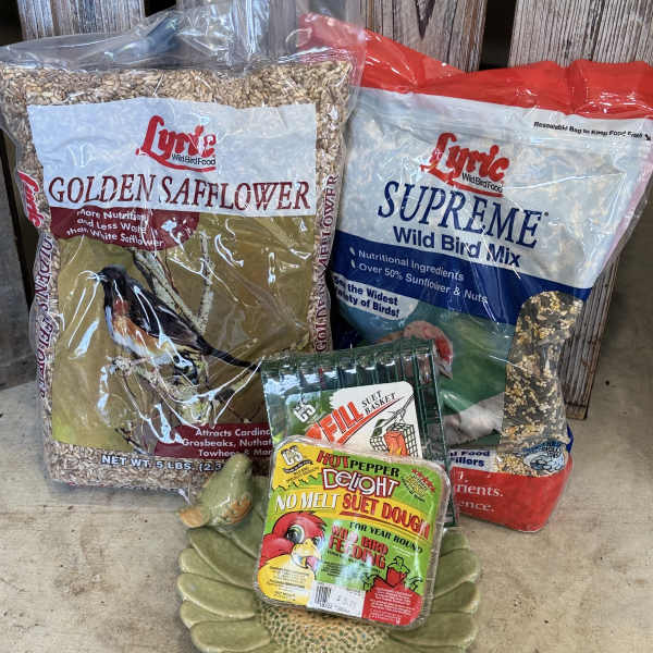 Bird food bags and suet cakes arranged on the floor
