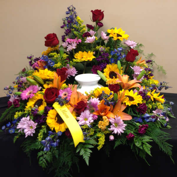 Colorful floral funeral wreath with a white urn in the center