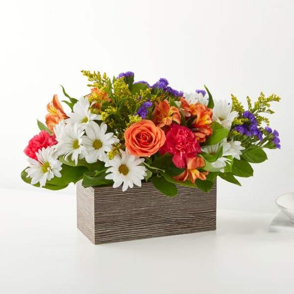 Mixed bouquet in a rectangular wood-look box with daisies, roses, carnations, and purple filler
