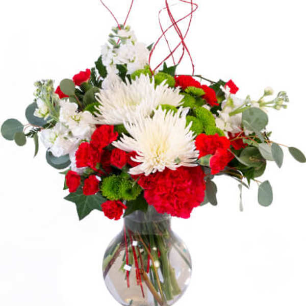Red and white flower arrangement in a clear glass vase