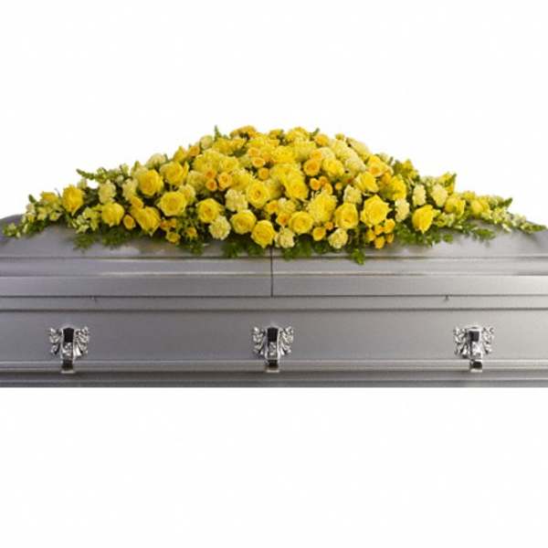 Yellow floral casket spray on a silver casket