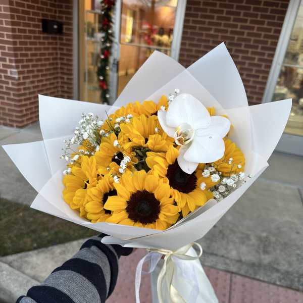 Bouquet of yellow sunflowers with a white orchid and baby's breath