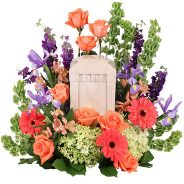 Cremation urn surrounded by orange roses, coral gerberas, green hydrangeas, purple iris and bells of Ireland