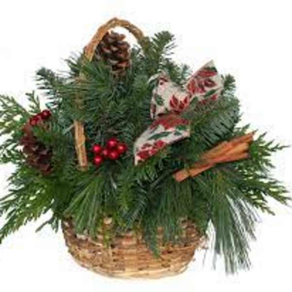 Basket of evergreen branches with pinecones and red berries