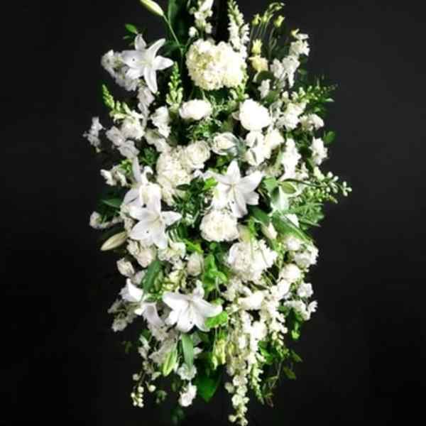 Tall white floral spray with lilies and mixed blooms