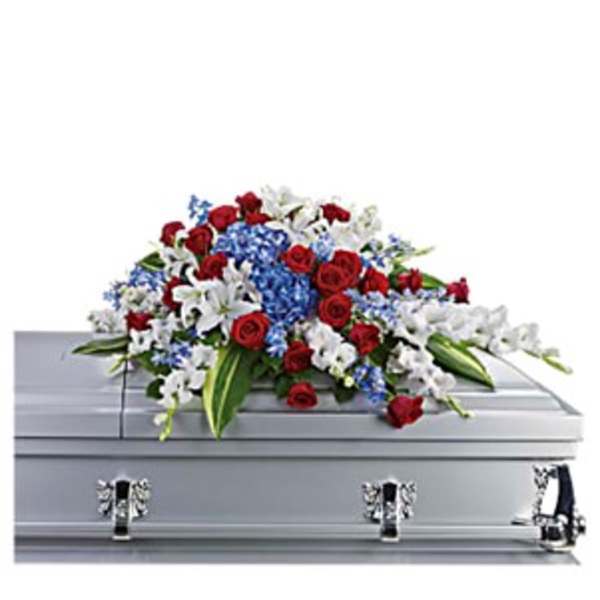 Red, white, and blue floral spray on a silver casket