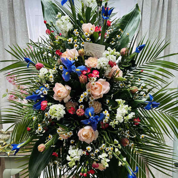 Large standing floral spray with blue and peach flowers