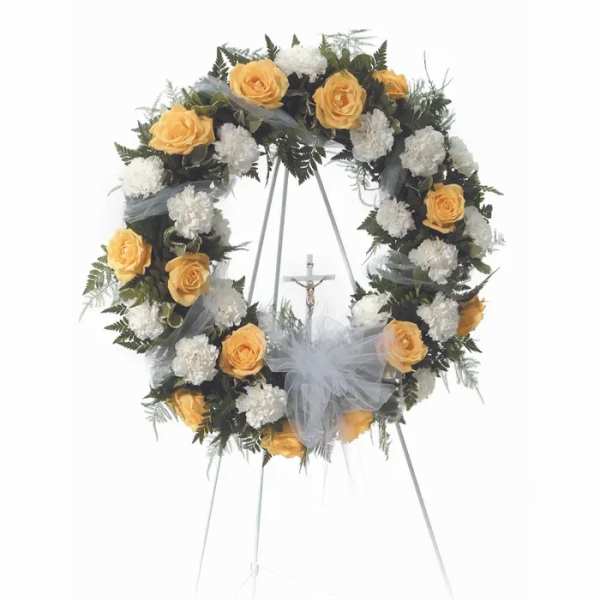 Floral funeral wreath with yellow roses and white carnations on a stand