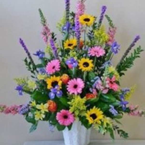 Colorful mixed flower arrangement in a white vase
