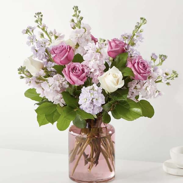 Pink and white roses in a pink glass vase