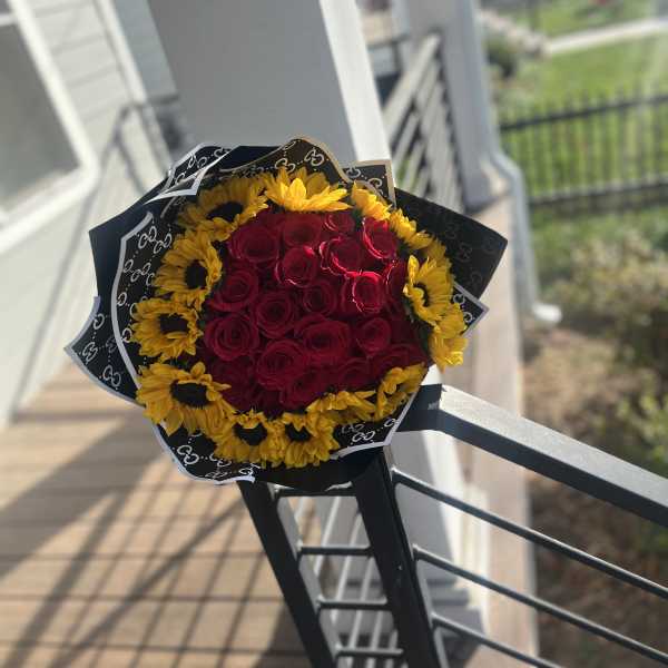 Bouquet of red roses surrounded by yellow sunflowers