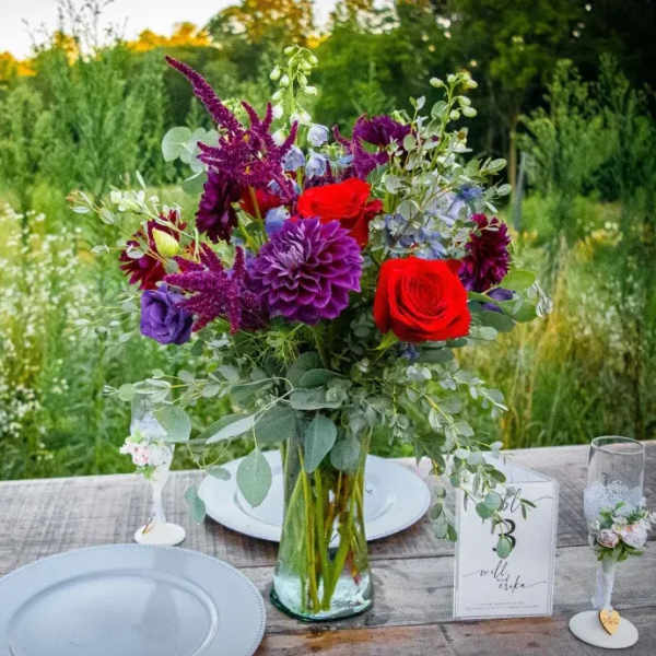 Bouquet of red and purple flowers in a glass vase on a table
