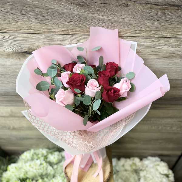 Bouquet of red and pink roses wrapped in pink paper