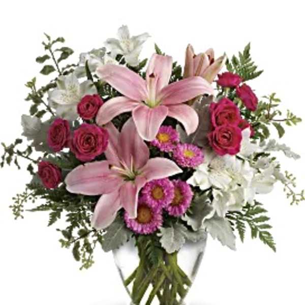 Pink lilies and roses in a clear glass vase