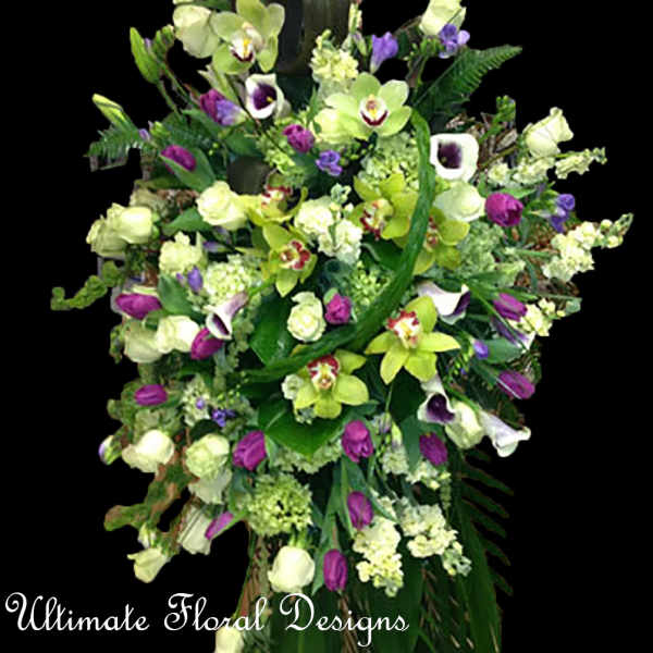 Tall floral spray with green orchids, purple blooms, and white flowers