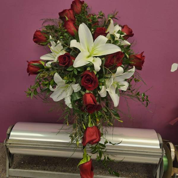 Red roses and white lilies arranged in a tall bouquet